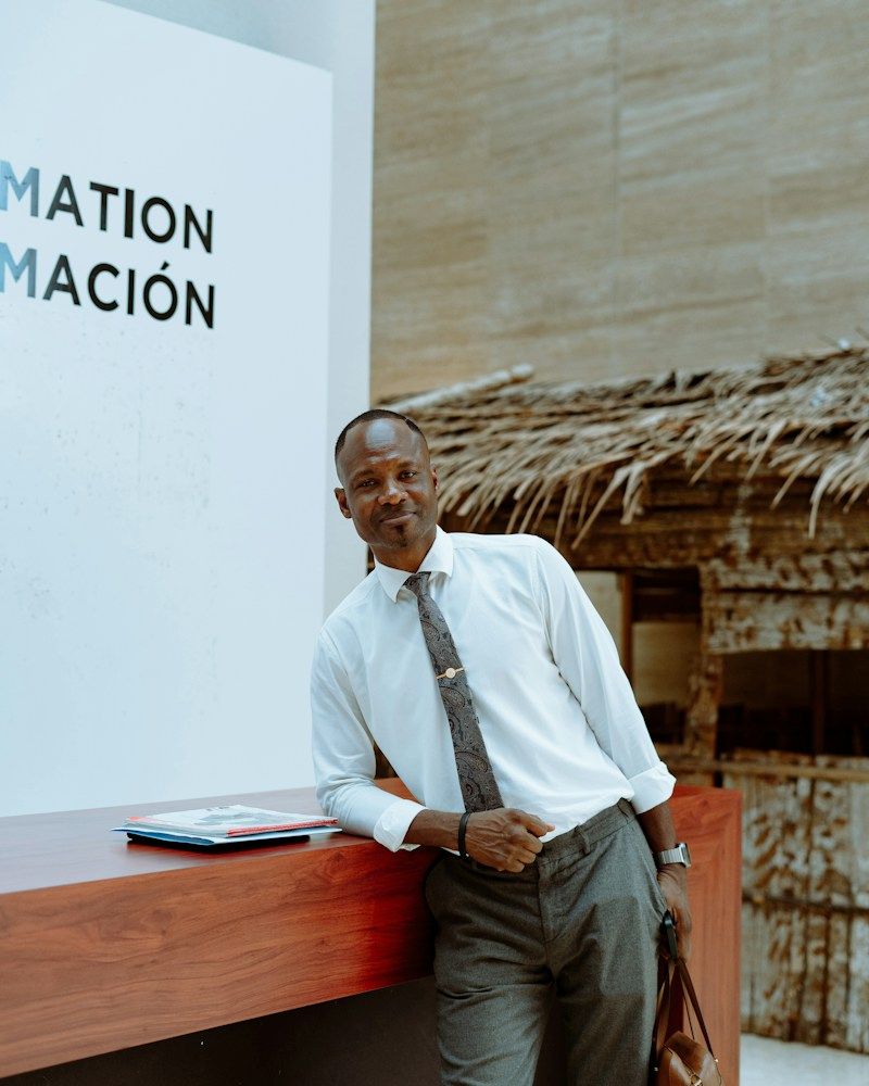 A hotel host in a shirt and tie at the reception counter