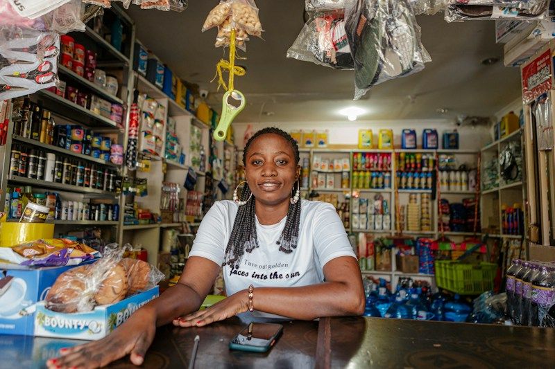 A smiling shop owner behind the counter of her store